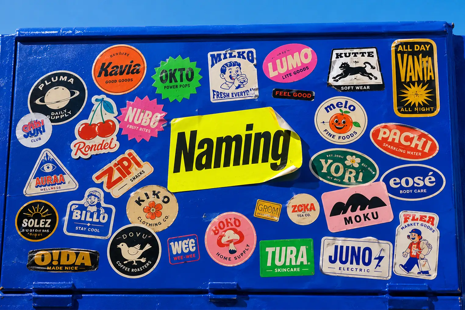 Caja eléctrica cubierta de stickers con nombres de marcas inventados, metáfora del proceso de naming