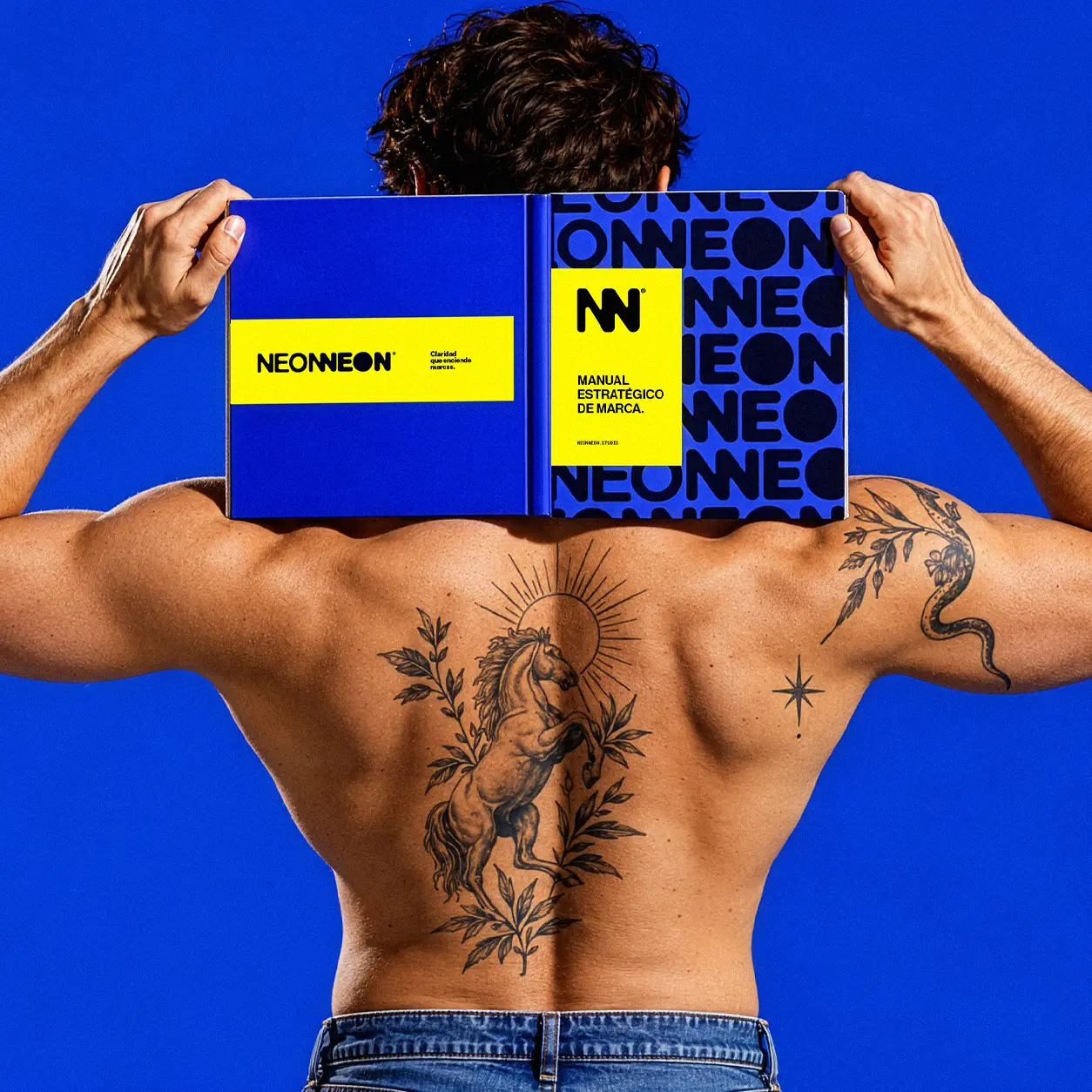 Portada del Manual Estratégico de Marca de Neon Neon Studio sostenida por un modelo de espaldas